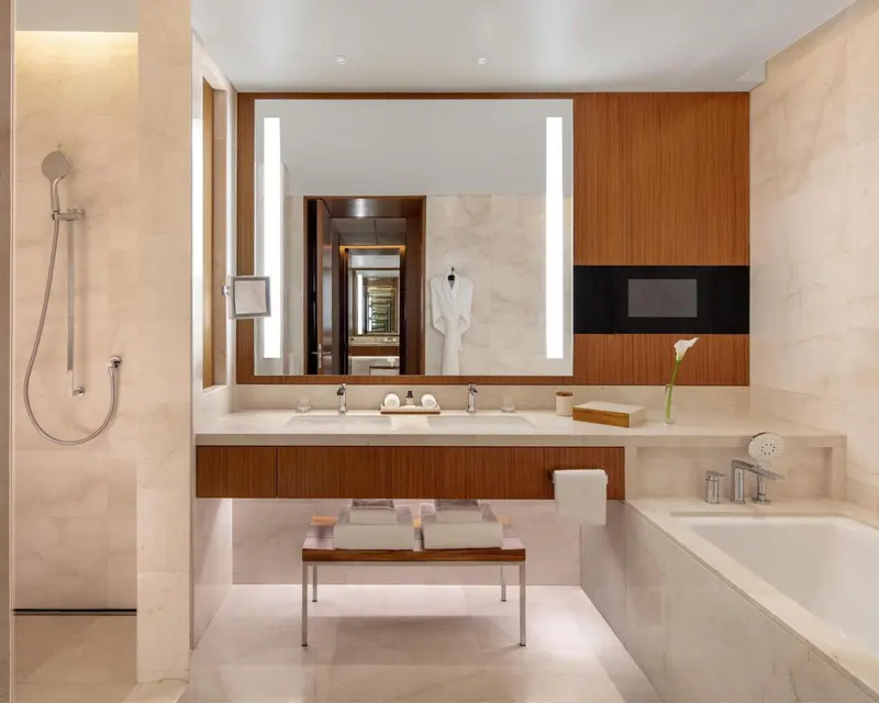 Une salle de bain lumineuse avec baignoire et double vasque.