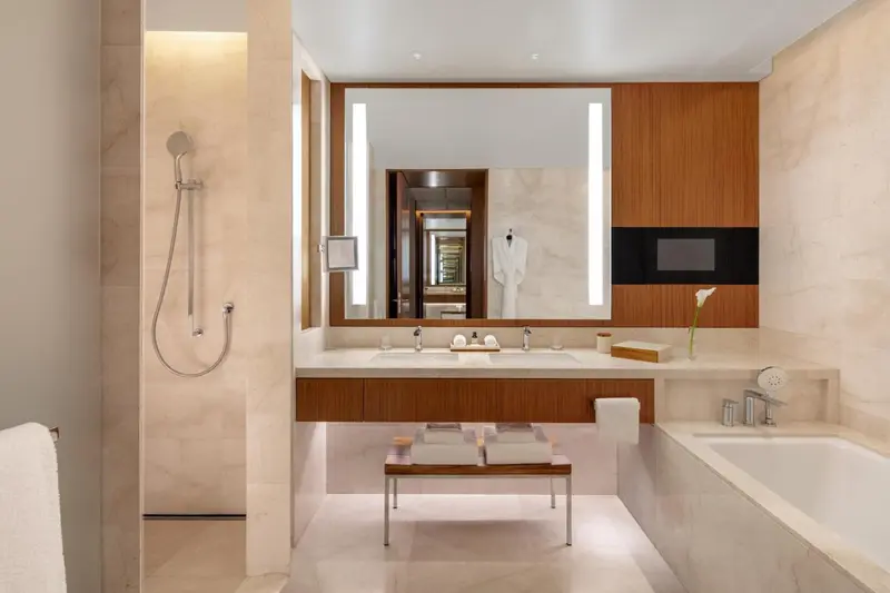 Une salle de bain moderne avec une baignoire et un grand miroir.