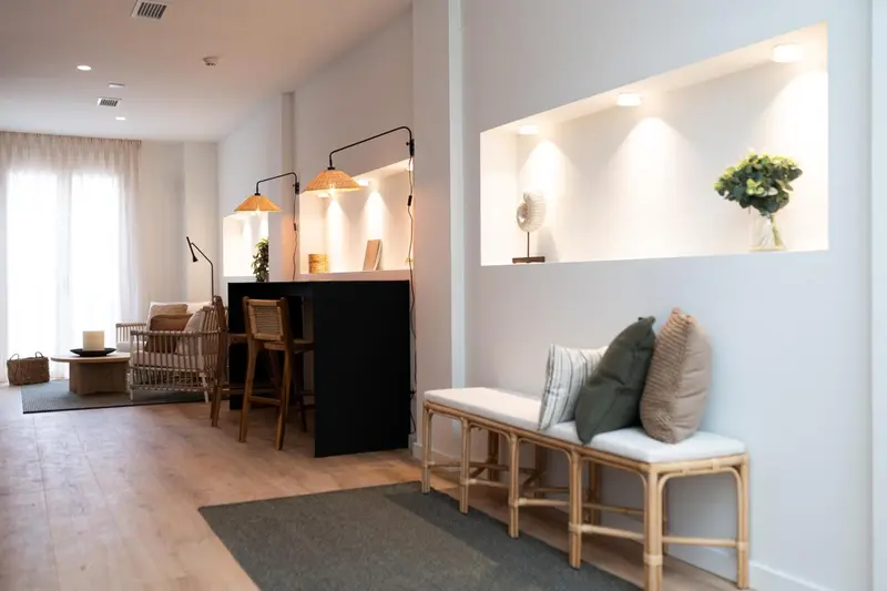 Un espace de vie intérieur lumineux avec un coin repas et un banc.