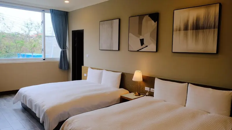 Une chambre lumineuse avec deux lits simples et des tableaux décoratifs.