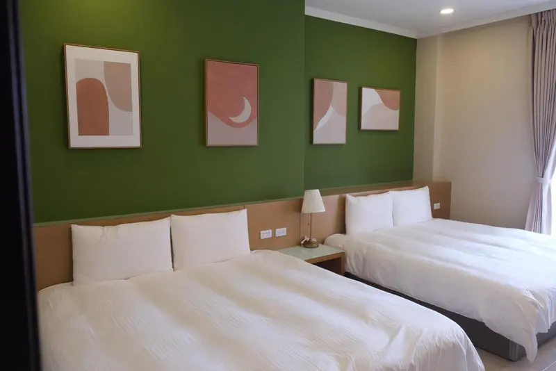 Chambre avec deux lits simples et décoration murale.