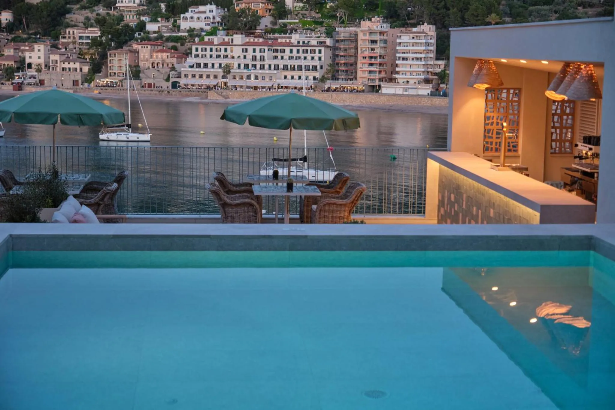 Terrasse avec piscine et vue sur la mer et les bâtiments environnants.