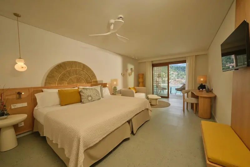 Une chambre lumineuse avec un grand lit et un accès à une terrasse.