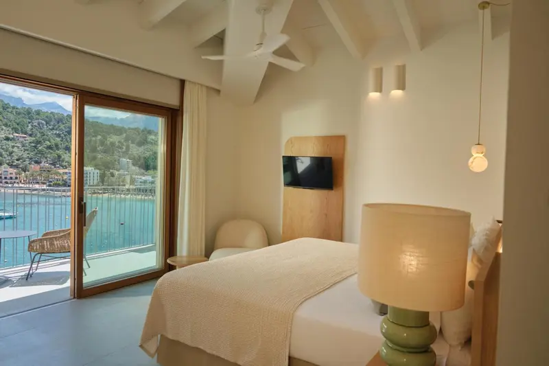 Une chambre lumineuse avec un grand lit et un accès à un balcon.