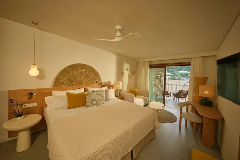 Une chambre lumineuse avec un grand lit et un accès à une terrasse.