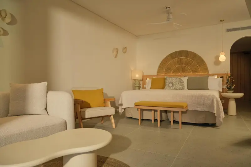 Une chambre lumineuse avec un canape et un grand lit.