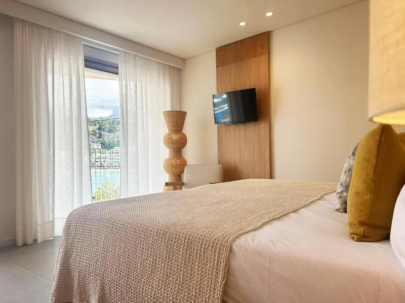 Une chambre lumineuse avec un grand lit et une vue sur la mer.