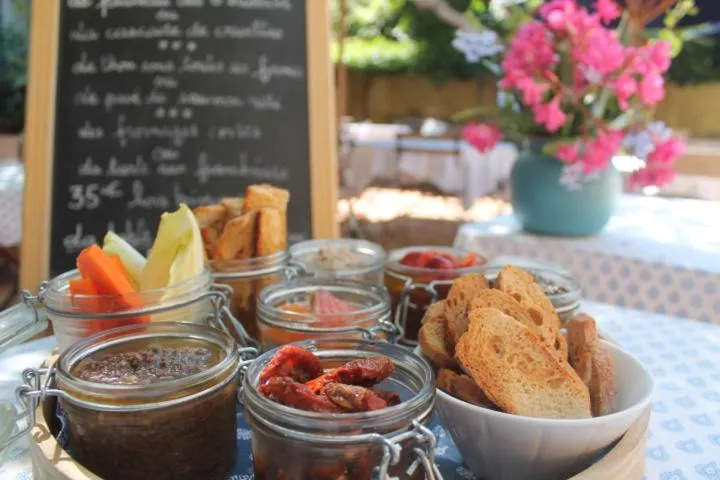 Assortiment de tapas et de crudités disposés sur une table en extérieur.