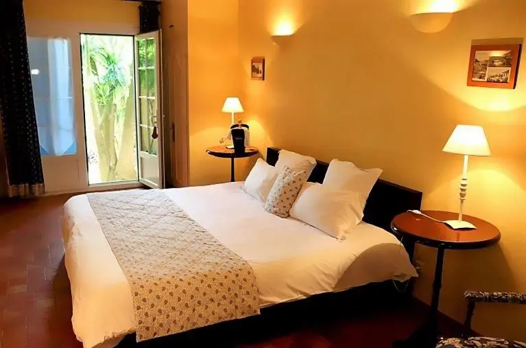 Une chambre lumineuse avec un grand lit et une vue sur une végétation luxuriante.