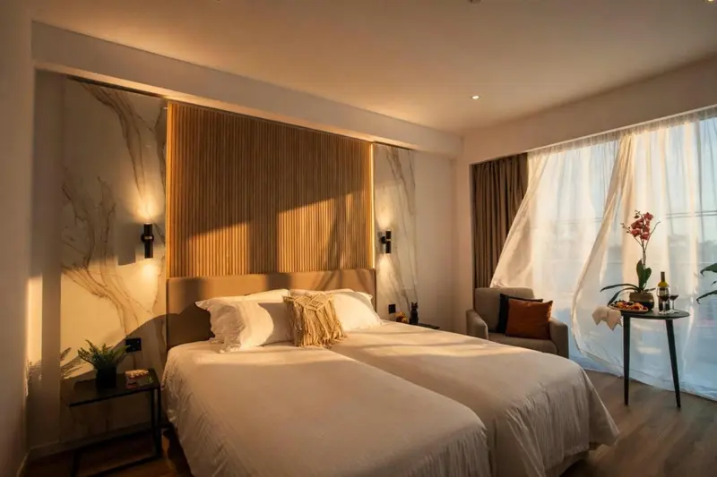 Une chambre lumineuse avec un grand lit et une table de chevet.