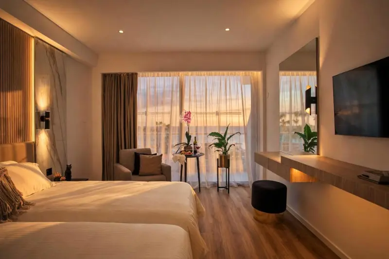 Chambre lumineuse avec un lit confortable et une vue sur la mer.