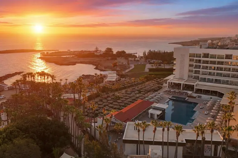 Vue aérienne d'un complexe hôtelier au bord de la mer au coucher du soleil.