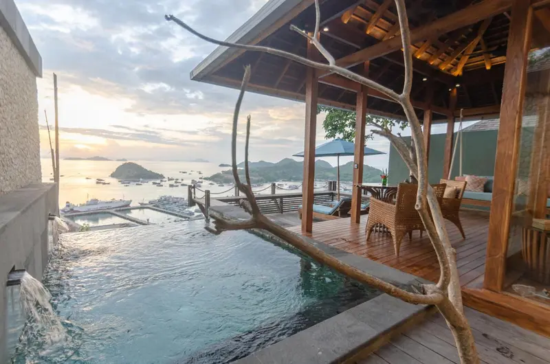Terrasse avec piscine à débordement donnant sur une baie.
