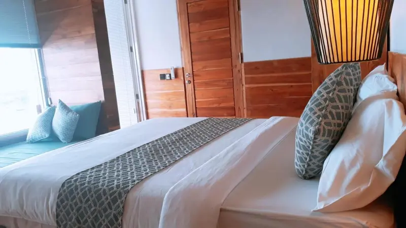 Une chambre avec un lit recouvert d'une courtepointe et de coussins.