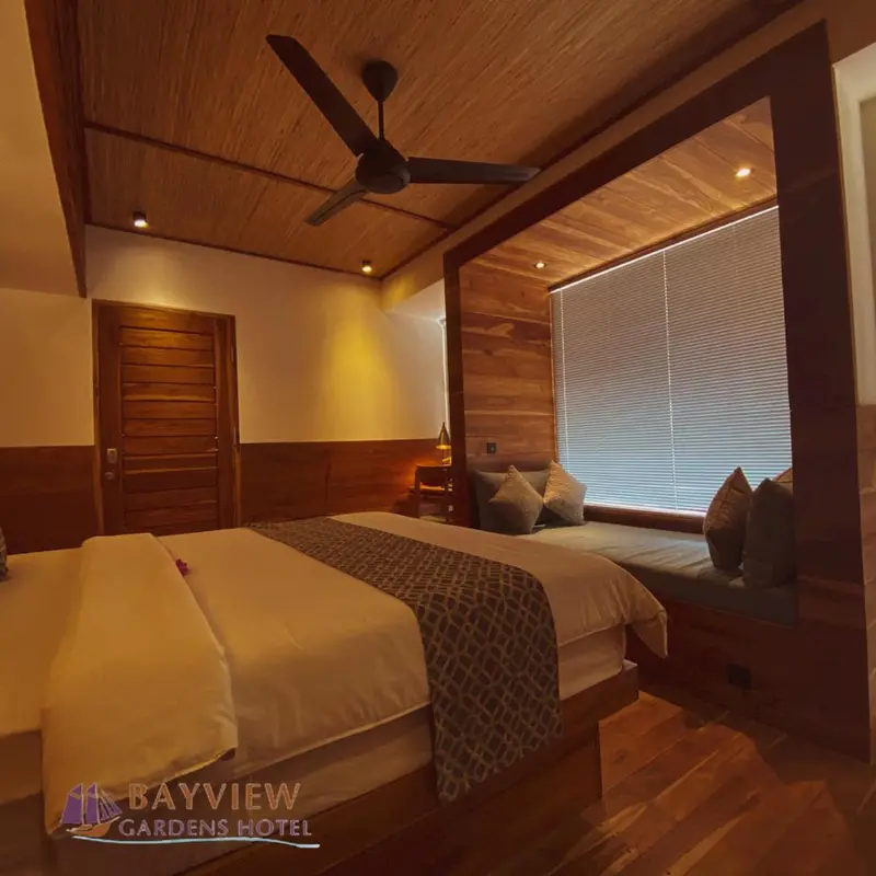 Une chambre lumineuse avec un lit double et un ventilateur de plafond.