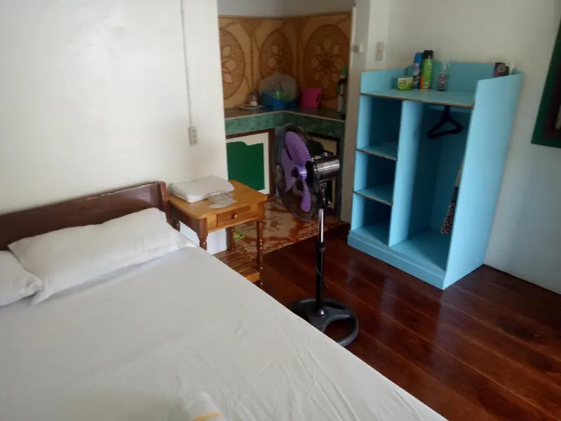 Une chambre lumineuse avec un lit simple et un espace rangement.