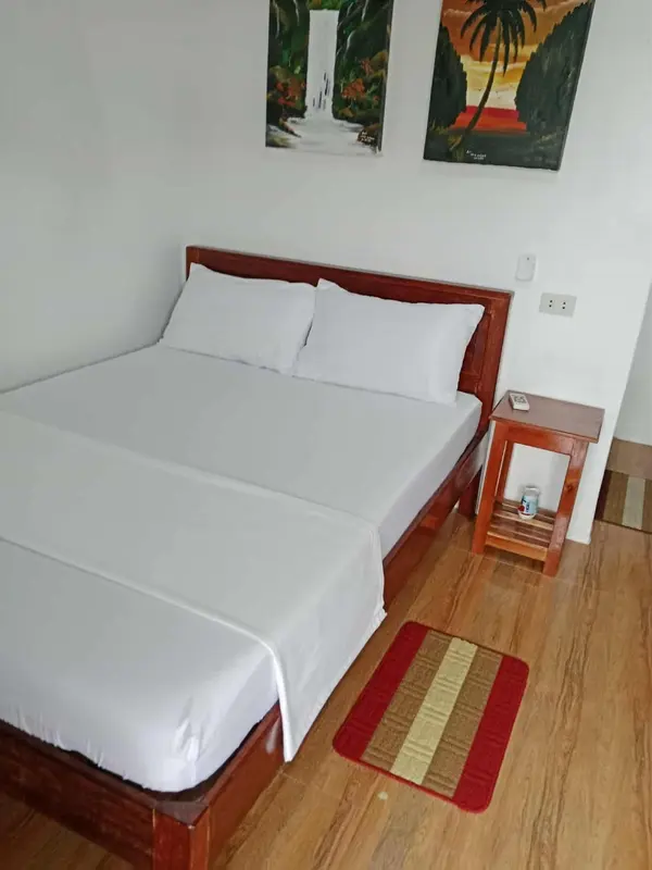 Une chambre lumineuse avec un lit double et une décoration murale colorée.