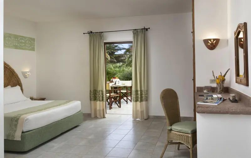 Une chambre lumineuse avec un lit et un accès à une terrasse.