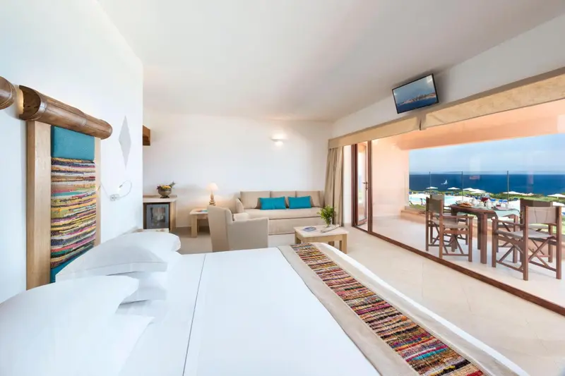 Chambre lumineuse avec canapé et accès à une terrasse vue mer.