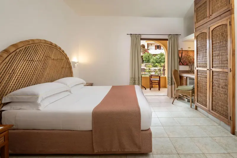 Une chambre lumineuse avec un grand lit et un accès à une terrasse.