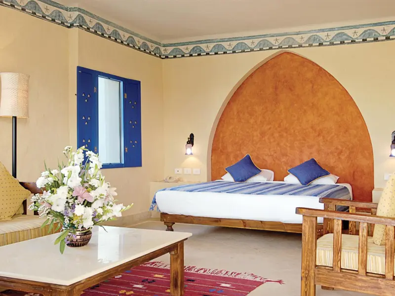 Une chambre lumineuse avec un lit double et une décoration orientale.