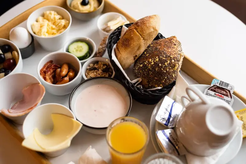 Un plateau de petit-déjeuner avec des viennoiseries, des fruits et des boissons.
