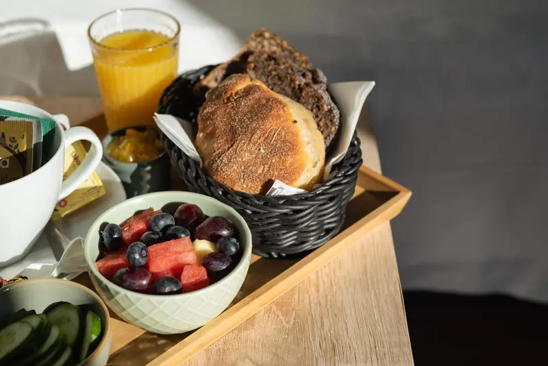 Un plateau de petit-déjeuner avec des viennoiseries, des fruits et une boisson.