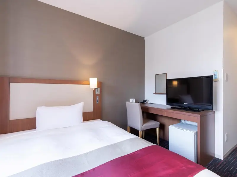 Une chambre d'hôtel avec un lit et un bureau.