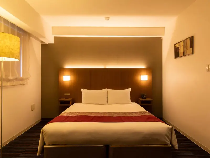 Une chambre lumineuse avec un grand lit et une décoration sobre.