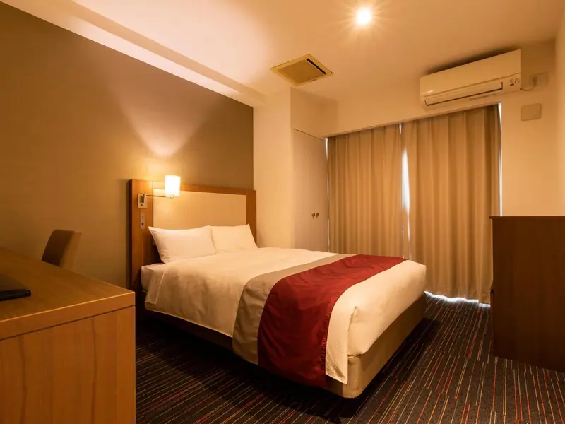Une chambre d'hôtel avec un lit double et un éclairage tamisé.