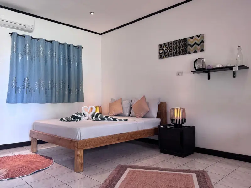 Une chambre lumineuse avec un lit recouvert d'une courtepointe décorative.