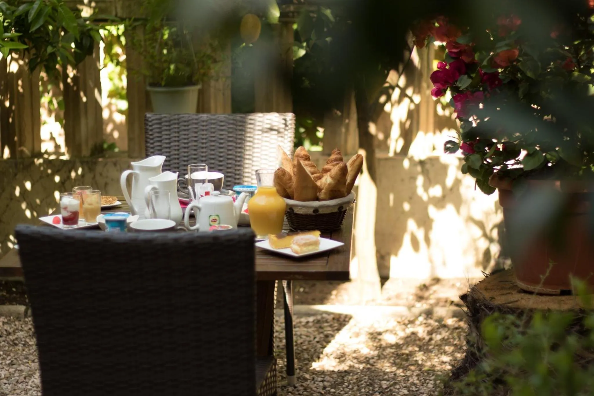 Une table de petit-déjeuner est dressée sur une terrasse ensoleillée.