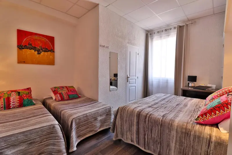 Une chambre avec deux lits simples et une décoration murale colorée.