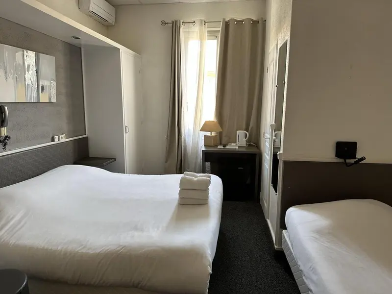 Une chambre d'hôtel avec un lit double et un lit simple.