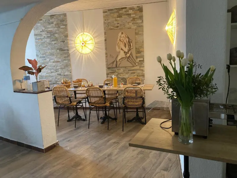 Une table à manger est mise en scène dans une pièce lumineuse avec une décoration murale.