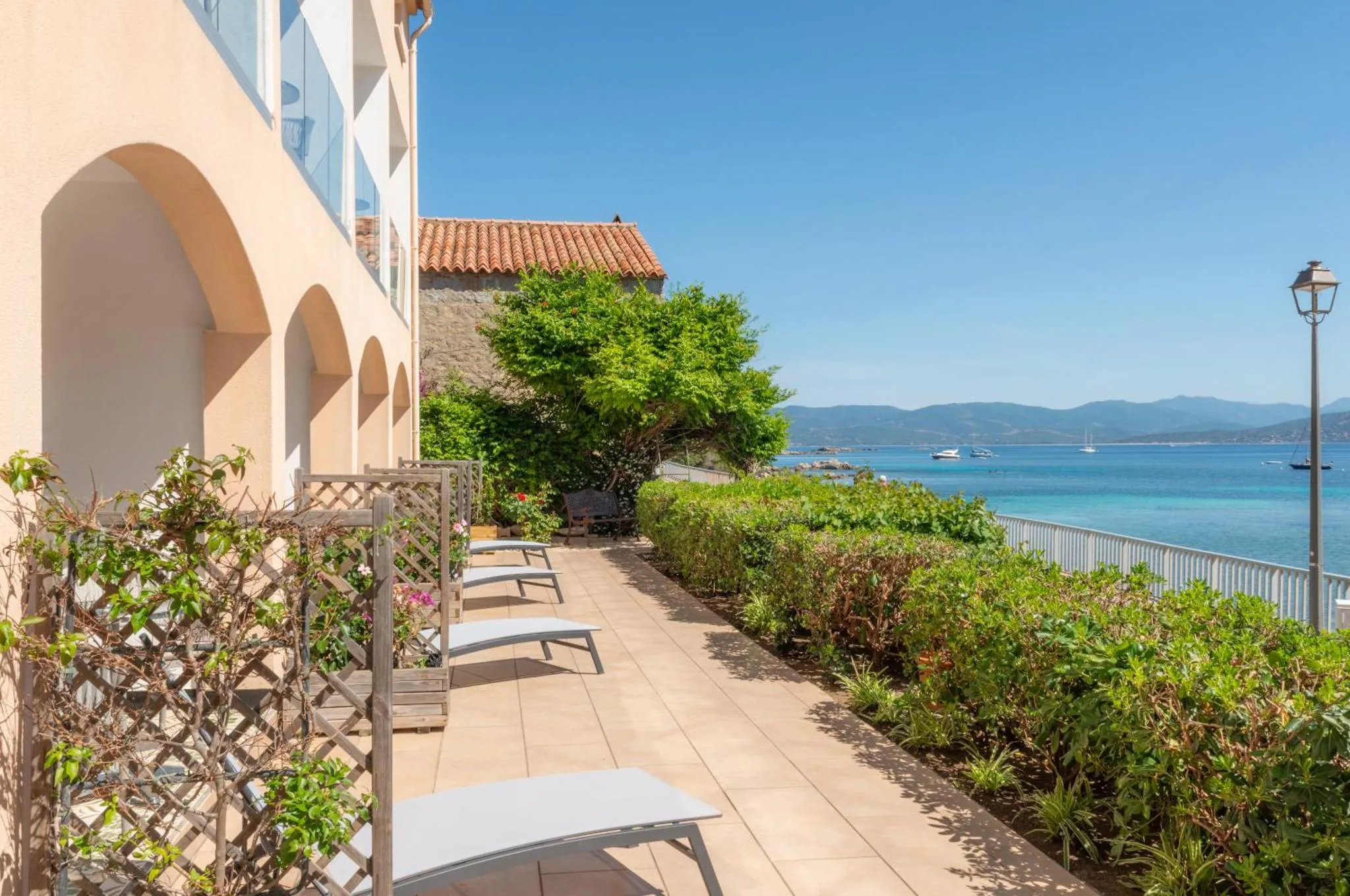 Terrasse avec transats et vue sur la mer.