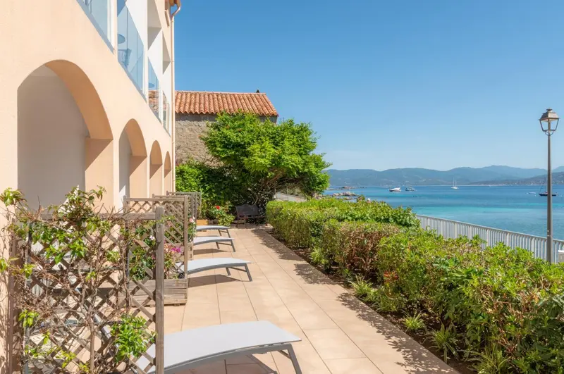 Terrasse avec transats et vue sur la mer.
