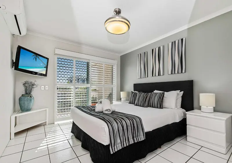 Une chambre lumineuse avec un grand lit et une décoration sobre.