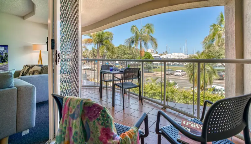 Une terrasse ensoleillée offre une vue sur la mer et la végétation tropicale.