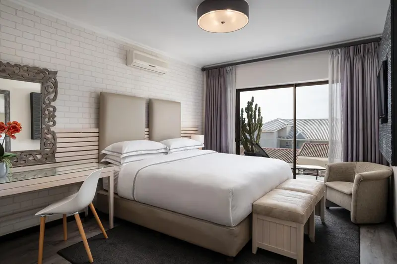 Une chambre lumineuse avec un grand lit et un bureau.