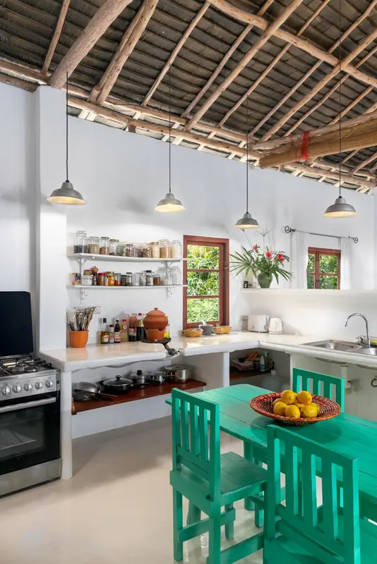 Une cuisine lumineuse avec un plan de travail et une table à manger verte.
