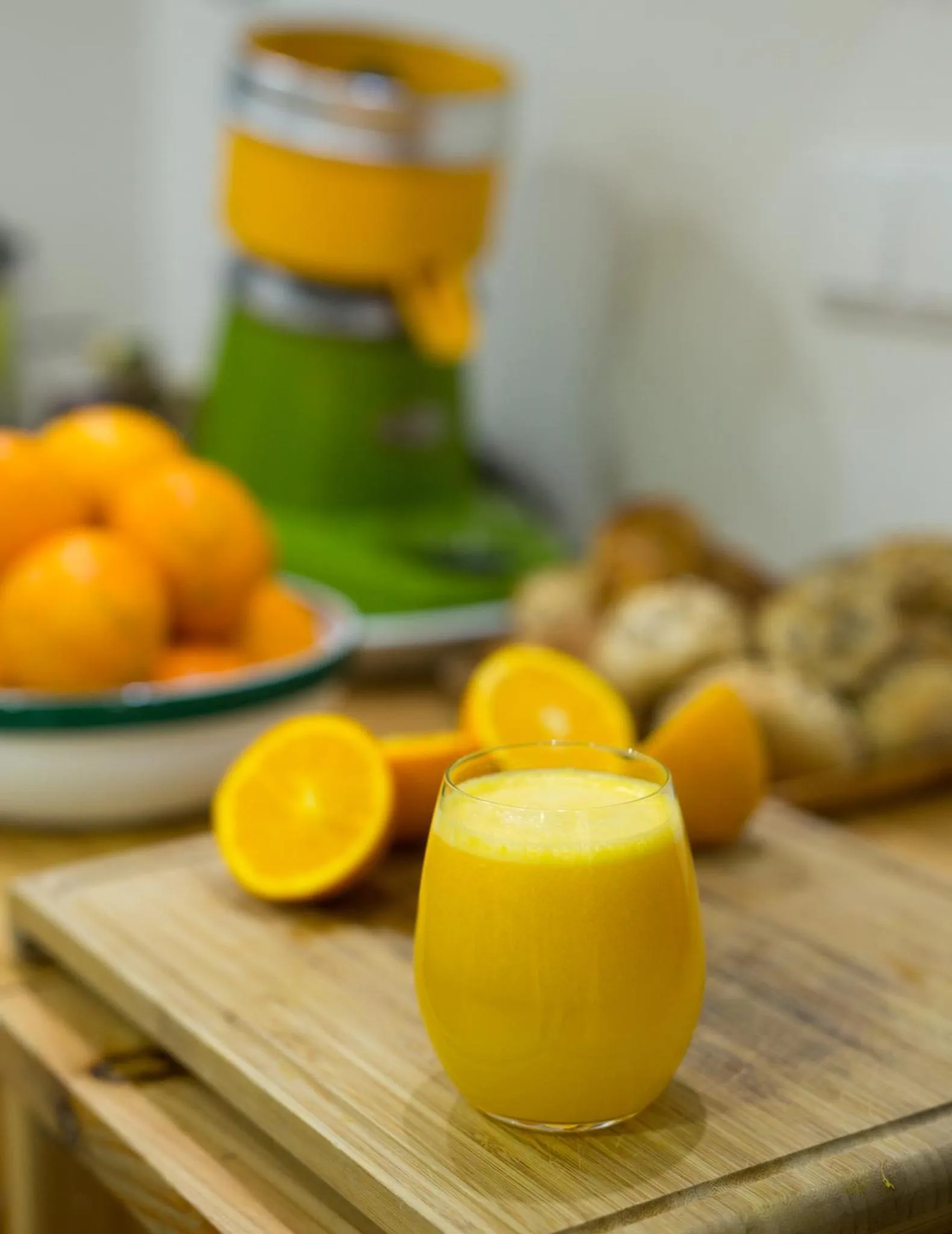 Un verre de jus d'orange frais est présenté avec des oranges et des pâtisseries.