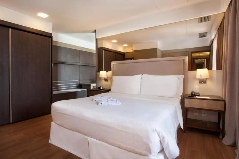 Une chambre d'hôtel moderne avec un grand lit et des meubles en bois.