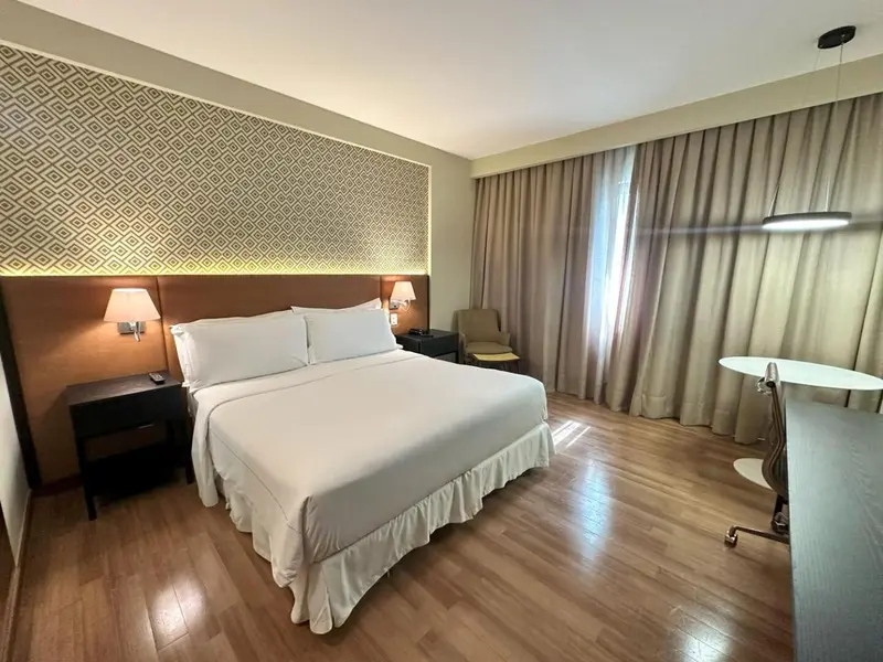 Une chambre d'hôtel lumineuse avec un grand lit et un espace bureau.