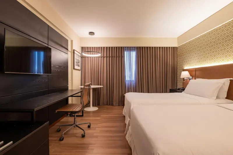 Chambre moderne avec un grand lit et un espace bureau.