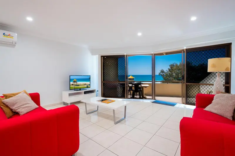 Un salon lumineux s'ouvre sur une terrasse avec vue sur la mer.