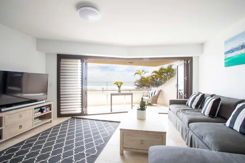 Un salon lumineux s'ouvre sur une terrasse avec vue sur la mer.