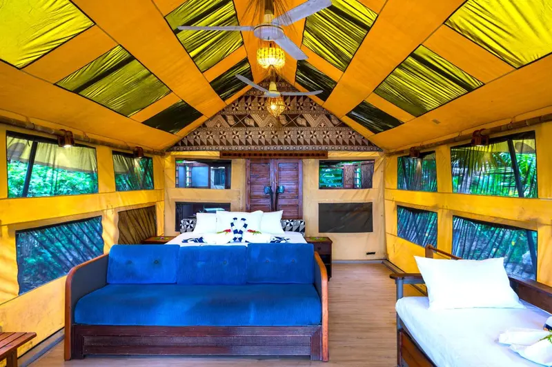 Intérieur d'une chambre avec un lit double et un canapé bleu.