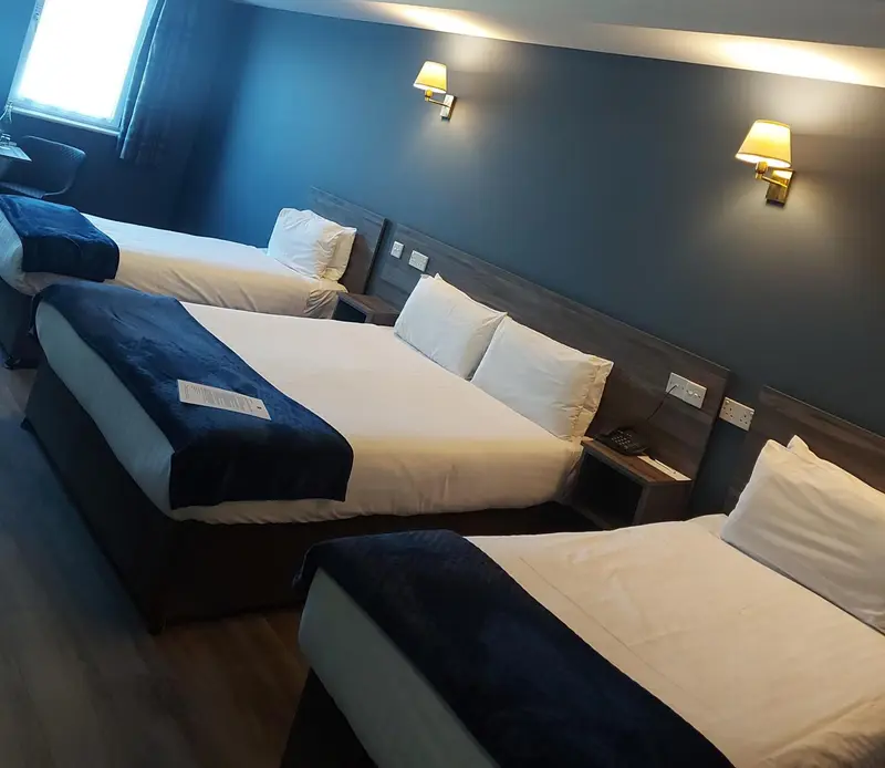 Une chambre d'hôtel avec des lits simples et une décoration sobre.
