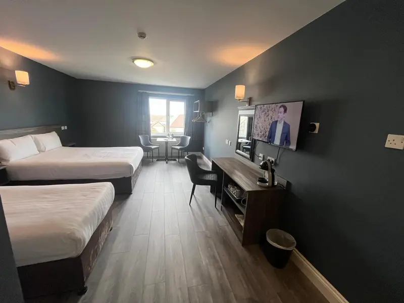 Une chambre d'hôtel moderne avec deux lits et un coin repas.